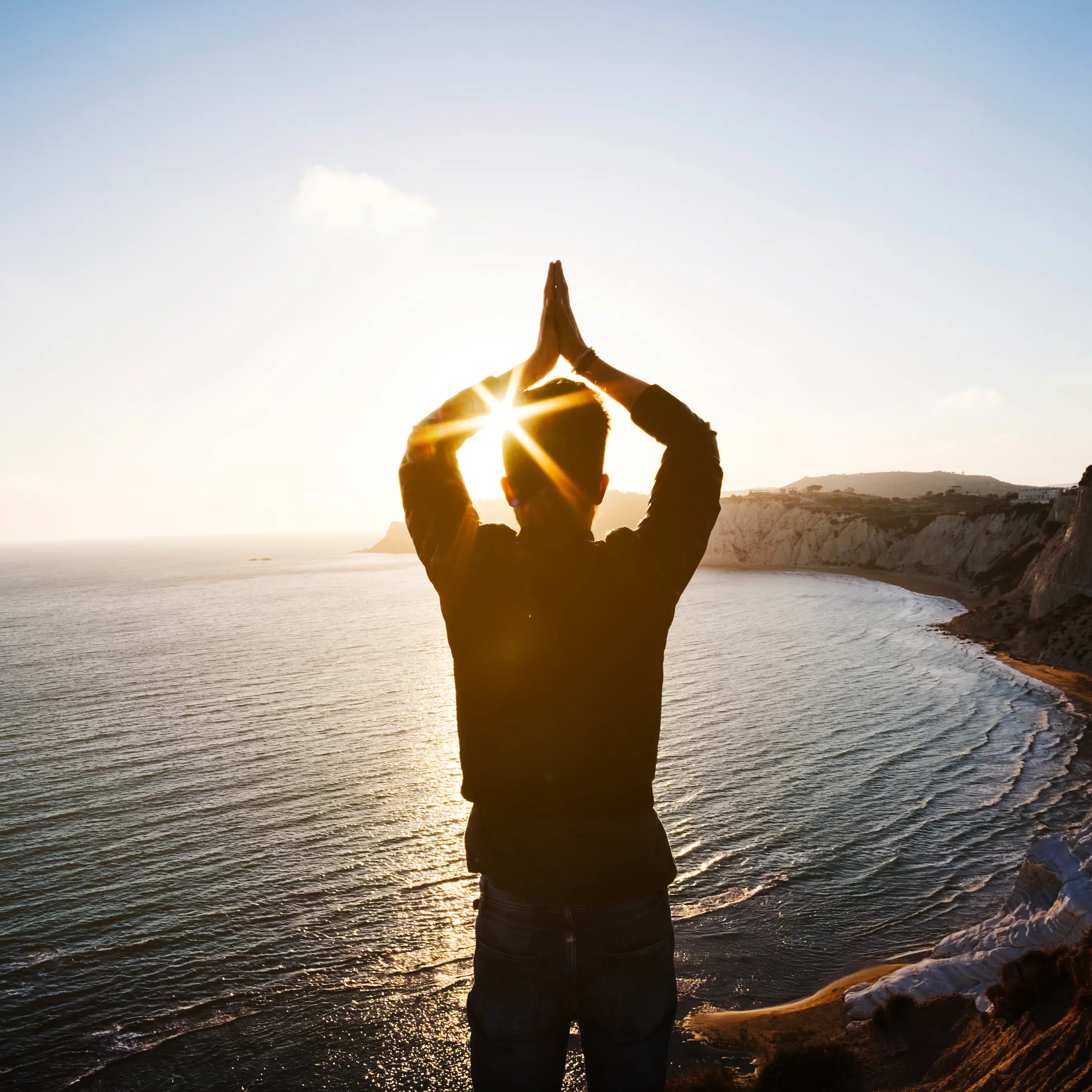 Persona practicando mindfulness al atardecer frente al mar, bienestar emocional y psicología en Clínica Merece Extremadura